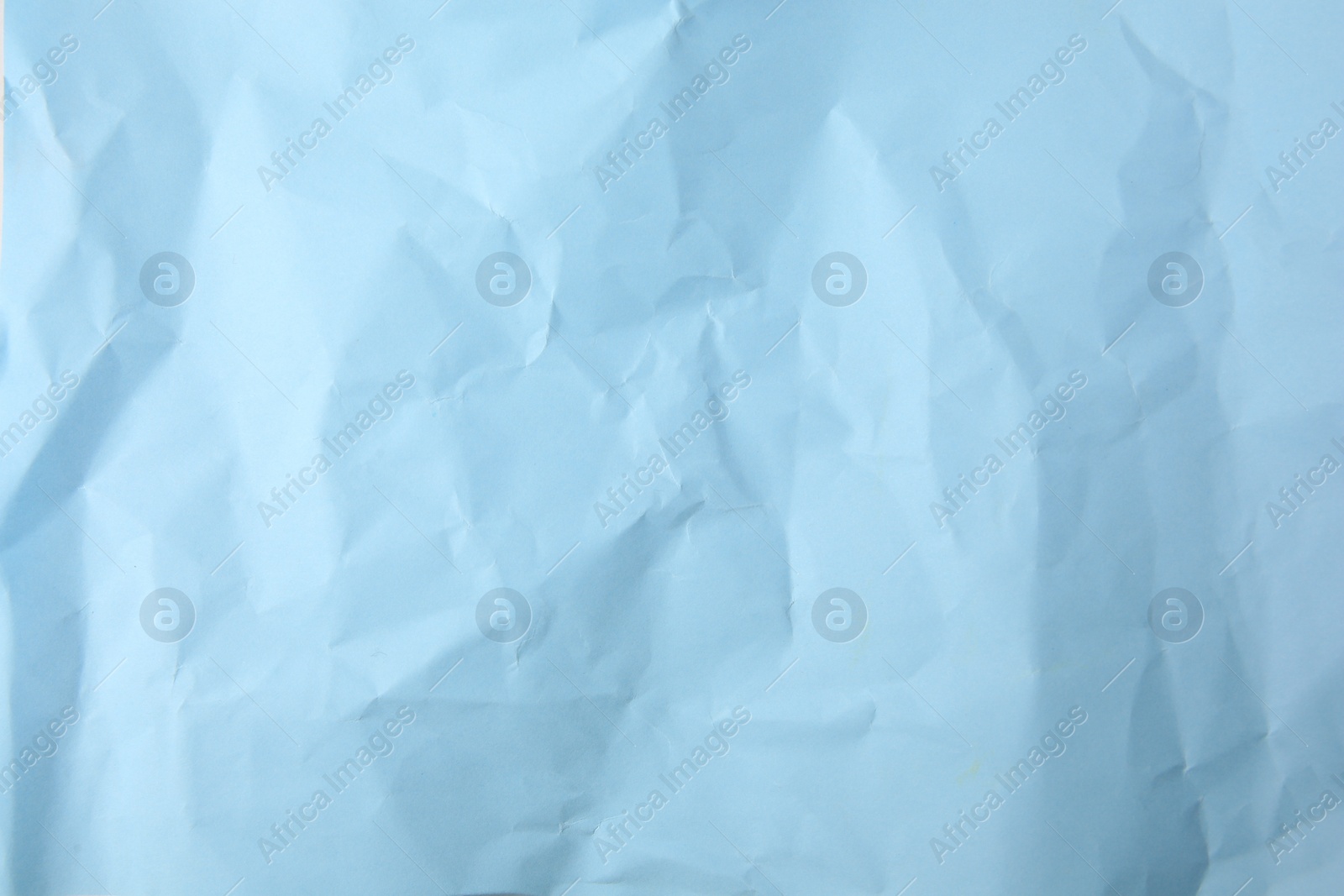 Photo of Sheet of crumpled light blue paper as background, top view