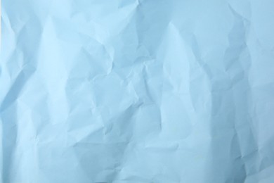 Photo of Sheet of crumpled light blue paper as background, top view