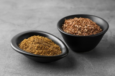 Photo of Caraway (Persian cumin) powder and dry seeds on gray table