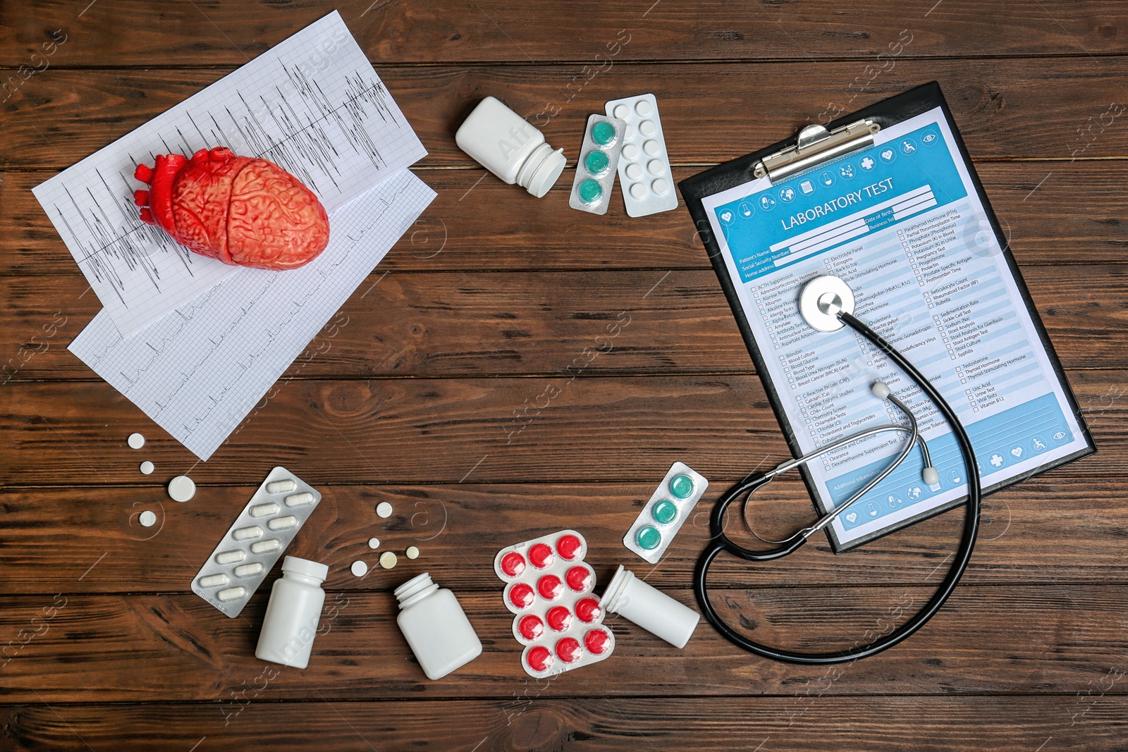Photo of Flat lay composition with stethoscope and pills on wooden background. Cardiology service