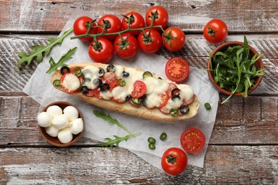 Tasty pizza toast and ingredients on wooden table, top view