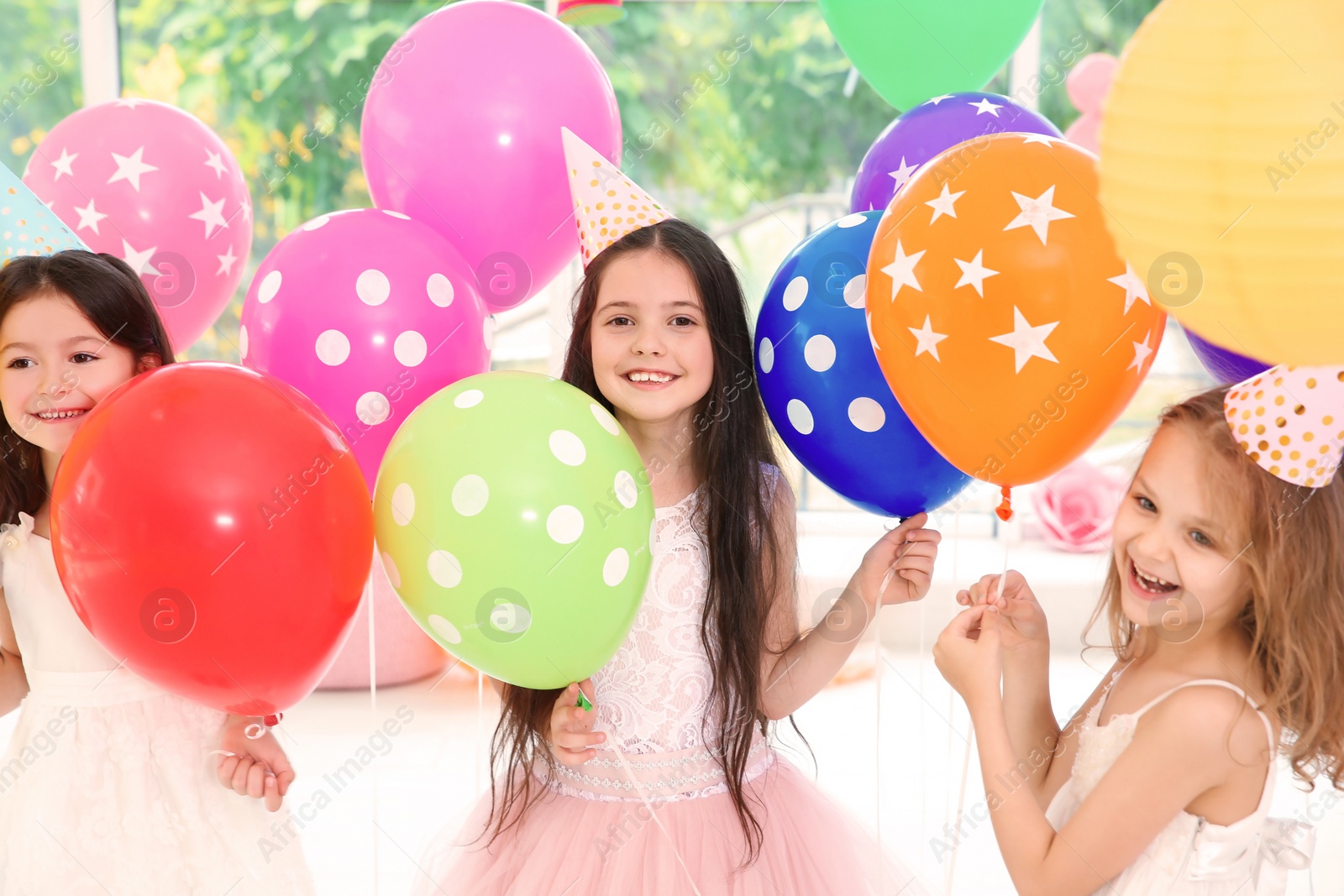 Photo of Cute girls with balloons at birthday party indoors