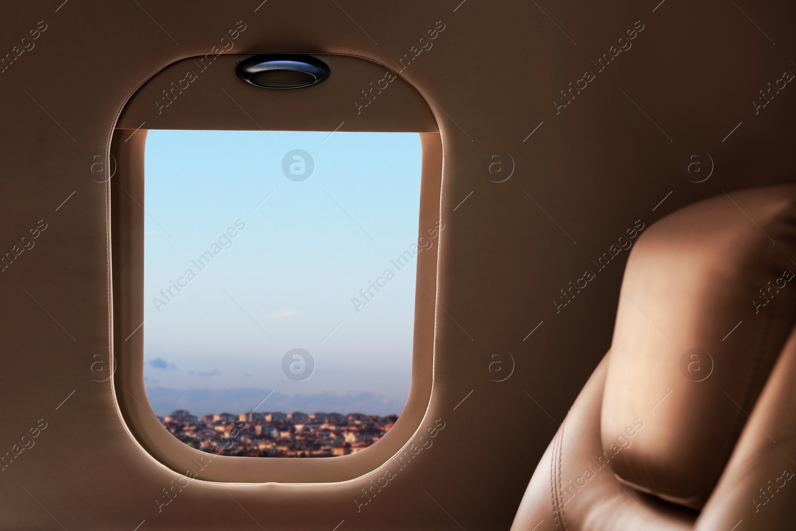 Image of Airplane cabin with comfortable seat during flight, focus on window