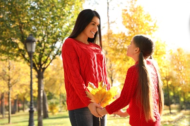 Photo of Happy mother and daughter spending time in park. Autumn walk