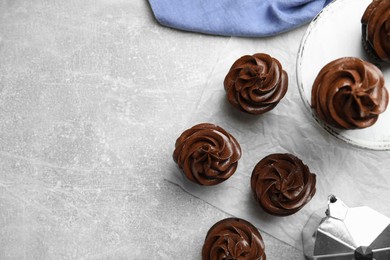 Photo of Flat lay composition with delicious chocolate cupcakes on grey table. Space for text