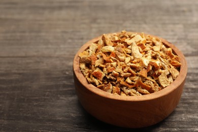 Bowl of dried orange zest seasoning on wooden table. Space for text