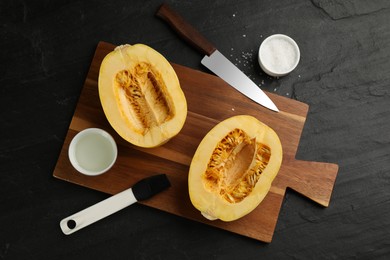 Photo of Flat lay composition with halves of fresh spaghetti squash on black table. Cooking vegetarian dish
