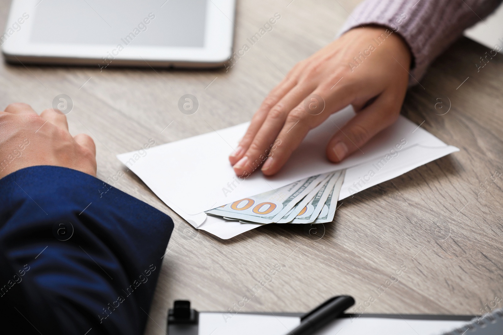 Photo of Woman offering bribe money at table, closeup