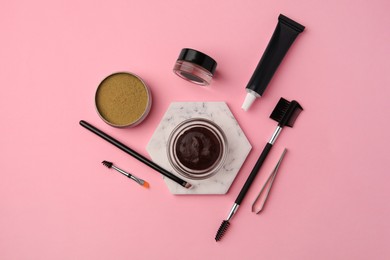 Photo of Flat lay composition with eyebrow henna and tools on pink background