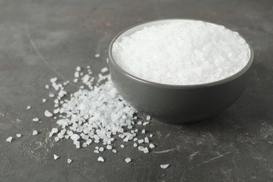 Photo of Bowl with natural sea salt on grey table