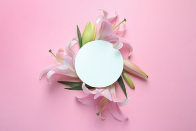 Photo of Blank card with fresh lily flowers on pink background, flat lay. Space for text