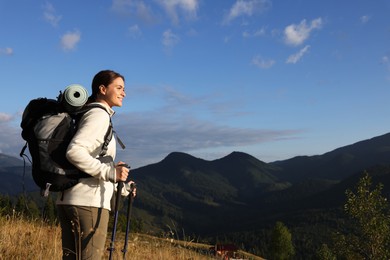 Photo of Tourist with backpack and trekking poles enjoying mountain landscape, space for text