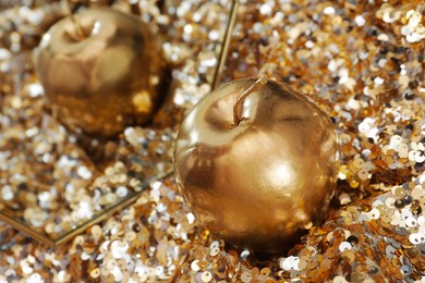 Photo of Golden apple and mirror on sequin fabric, closeup