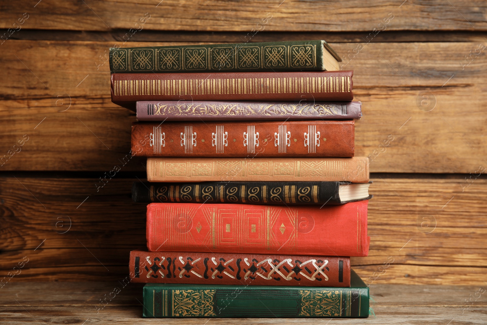 Photo of Collection of different books on table against wooden background