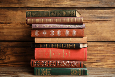 Collection of different books on table against wooden background