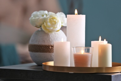 Photo of Burning candles on table against blurred background