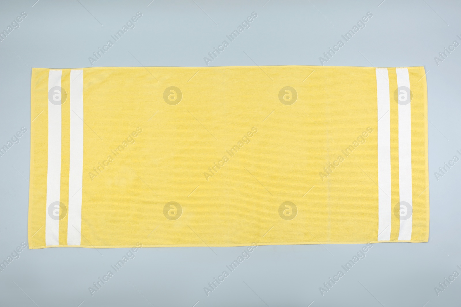 Photo of Yellow beach towel on light grey background, top view