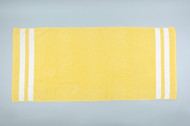 Photo of Yellow beach towel on light grey background, top view