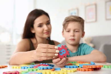 Young woman and little boy with autistic disorder playing at home, closeup