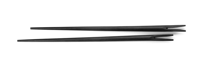 Photo of Pair of black chopsticks isolated on white, top view