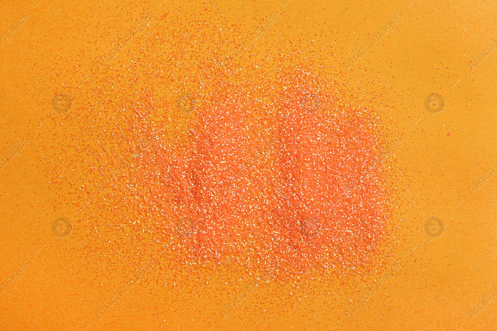 Photo of Shiny bright glitter on orange background, flat lay