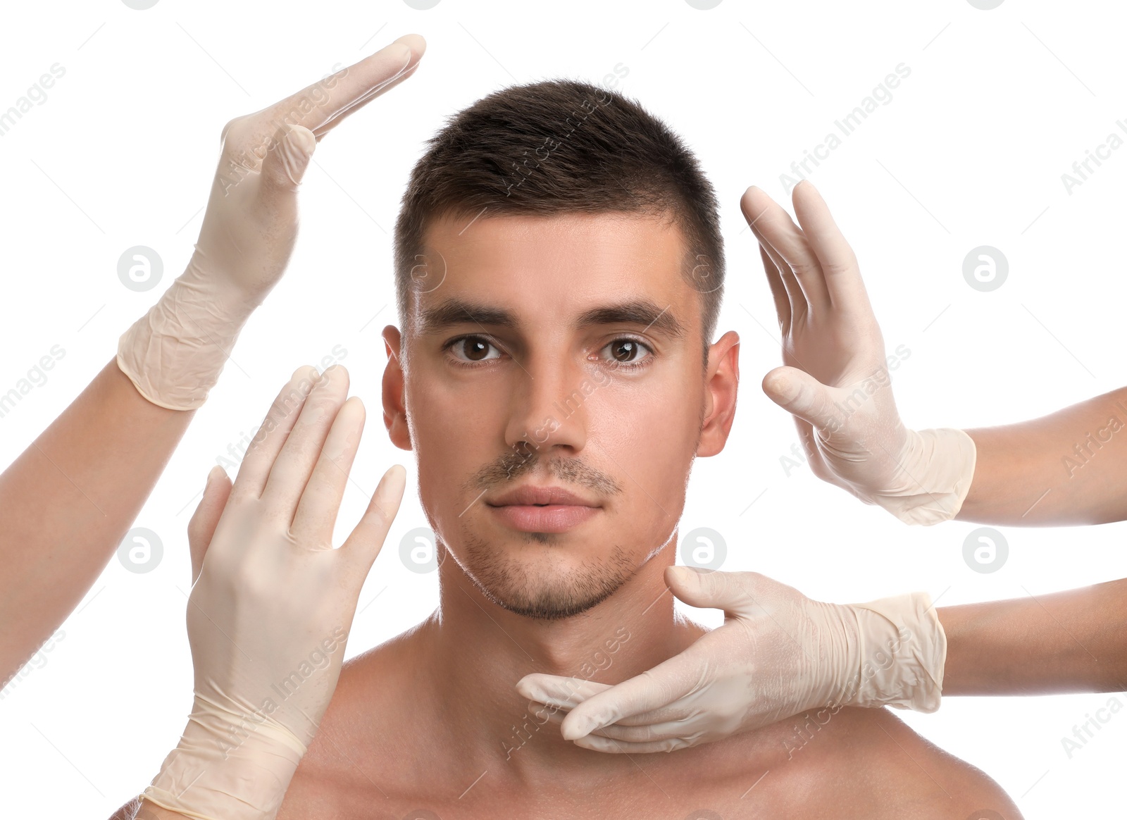 Photo of Doctors examining man's face for cosmetic surgery on white background