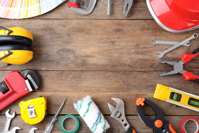 Photo of Flat lay composition with construction tools on wooden background. Space for text