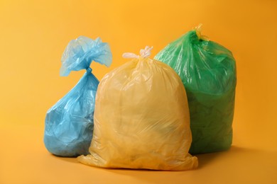 Trash bags full of garbage on yellow background