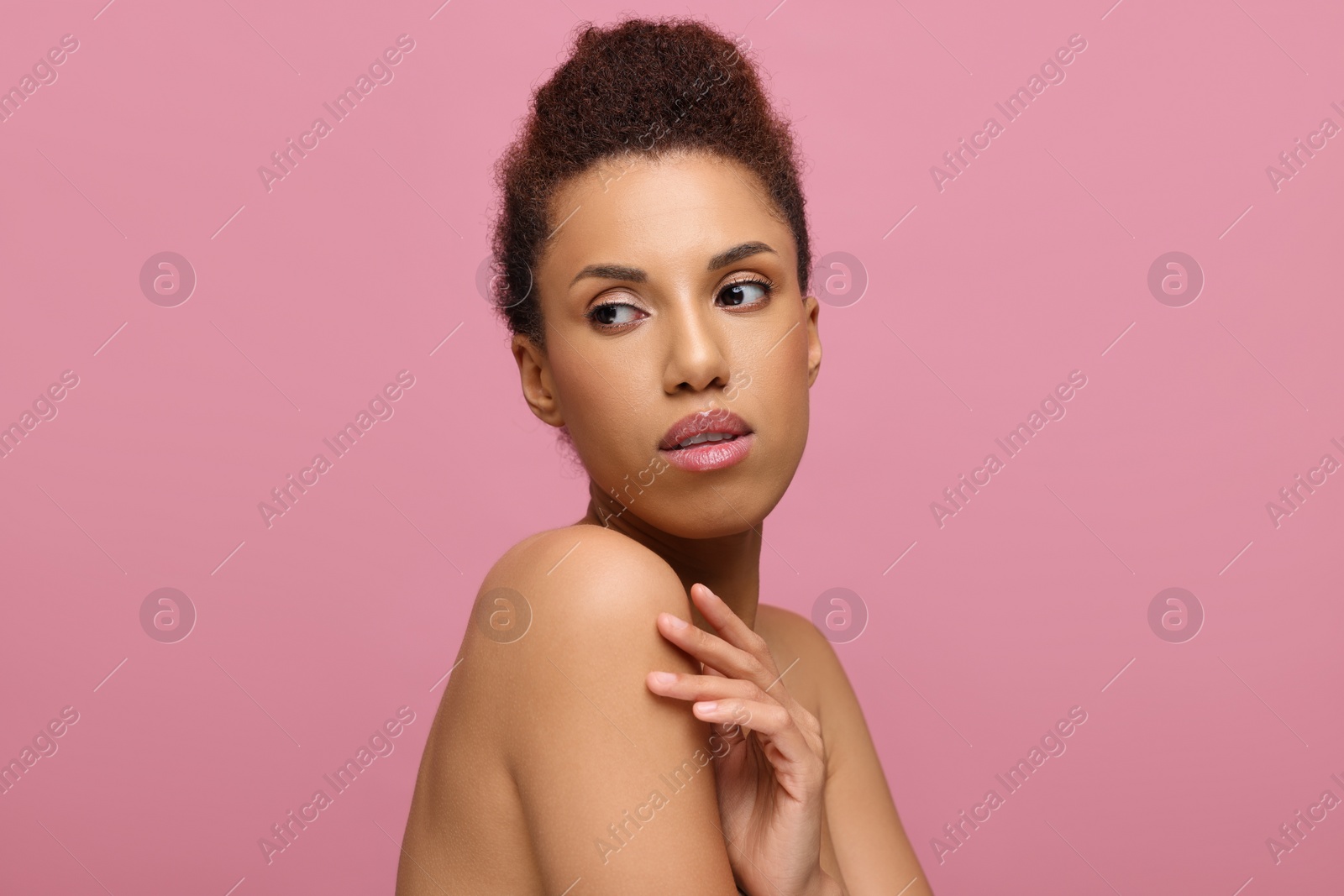 Photo of Portrait of beautiful young woman with glamorous makeup on pink background