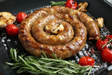 Delicious homemade sausage with garlic, tomatoes, rosemary and spices in grill pan, closeup