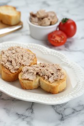 Photo of Tasty sandwiches with cod liver on white marble table