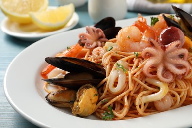 Photo of Delicious spaghetti with seafood served on table, closeup