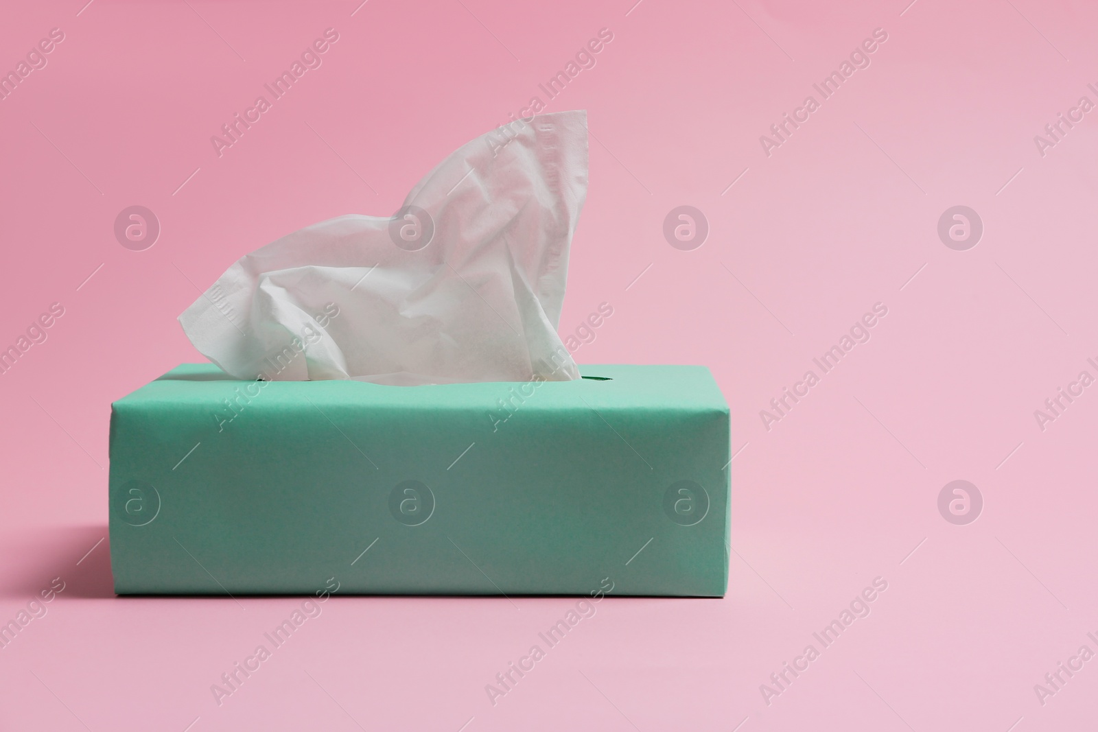 Photo of Box with paper tissues on pink background