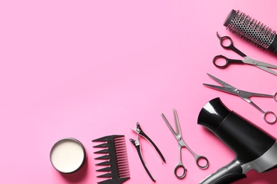 Scissors and other hairdresser's accessories on pink background, flat lay. Space for text