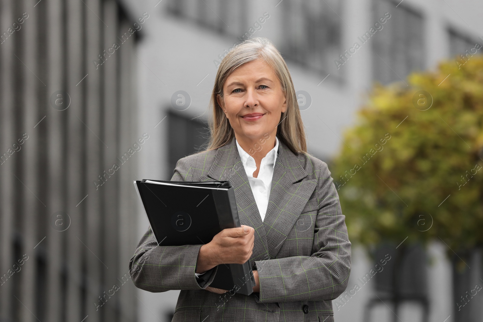 Photo of Beautiful woman with folders outdoors. Lawyer, businesswoman, accountant or manager