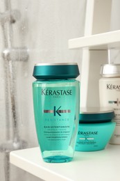 Photo of MYKOLAIV, UKRAINE - SEPTEMBER 07, 2021: Kerastase hair care cosmetic products on white shelf in bathroom