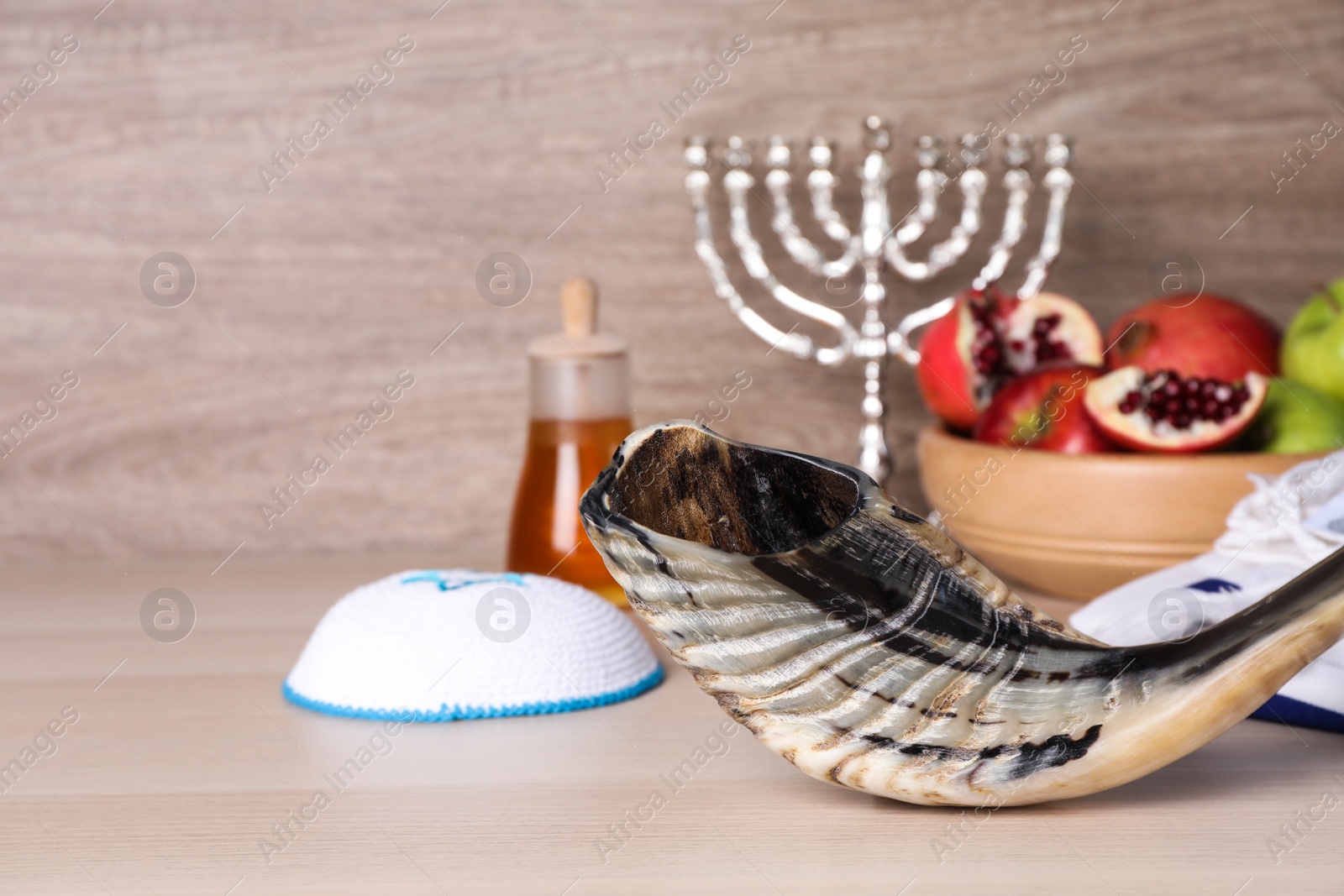 Photo of Shofar and other Rosh Hashanah holiday attributes on wooden table.