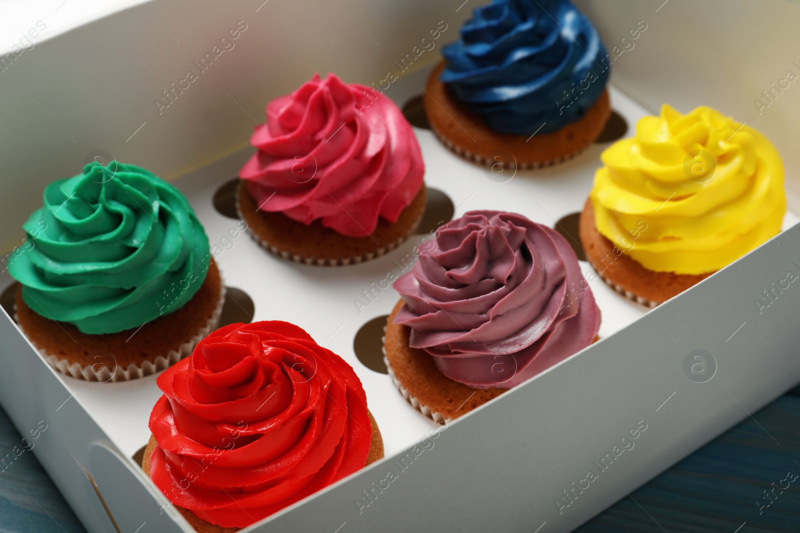 Photo of Different cupcakes with cream in box, closeup