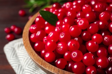 Photo of Plate with tasty ripe cranberries on table, closeup