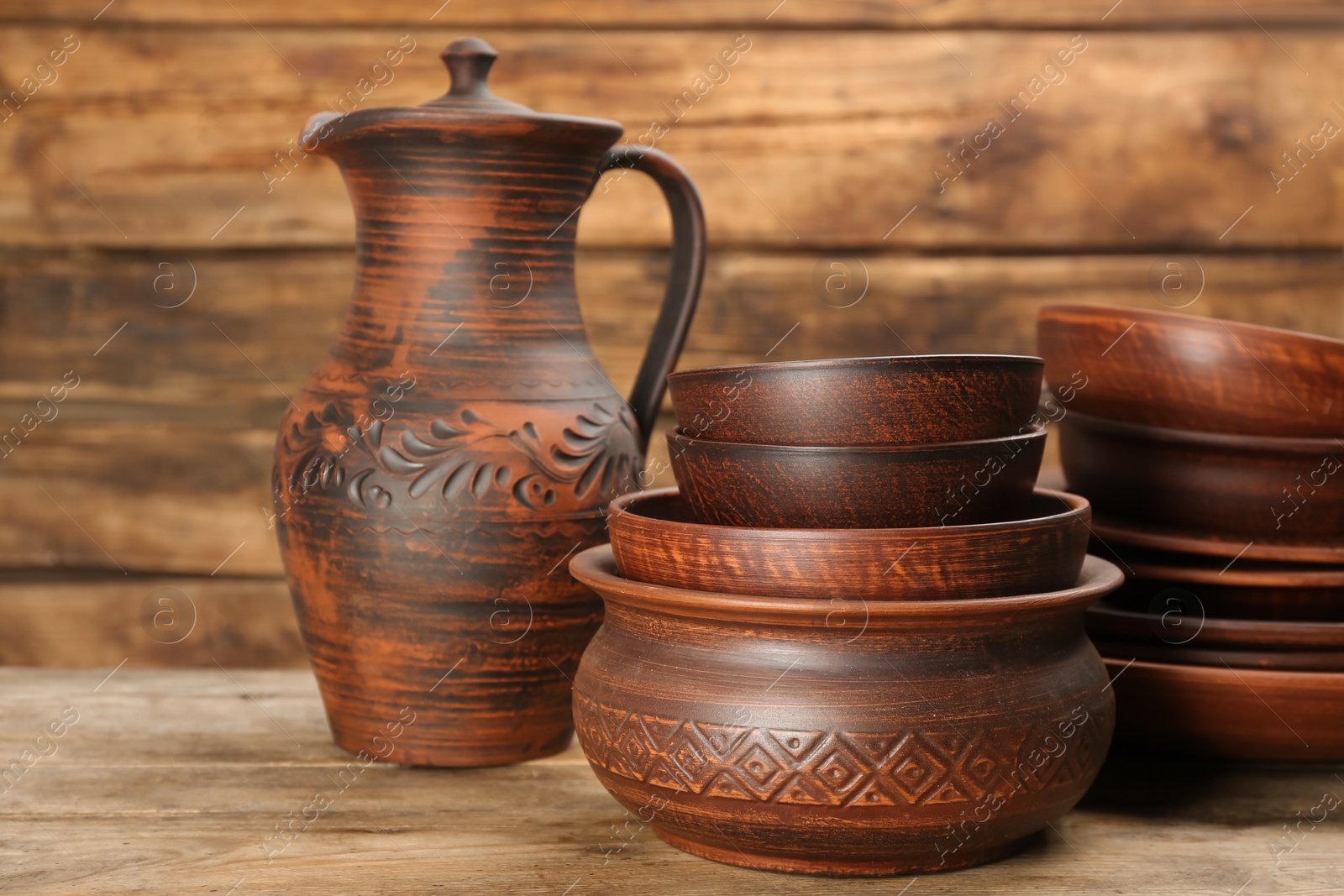 Photo of Set of clay utensils on wooden table