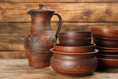 Set of clay utensils on wooden table