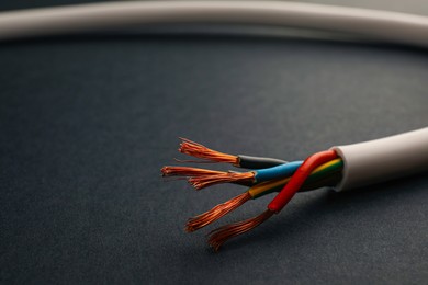 Photo of Cable with stripped wires on black background, closeup