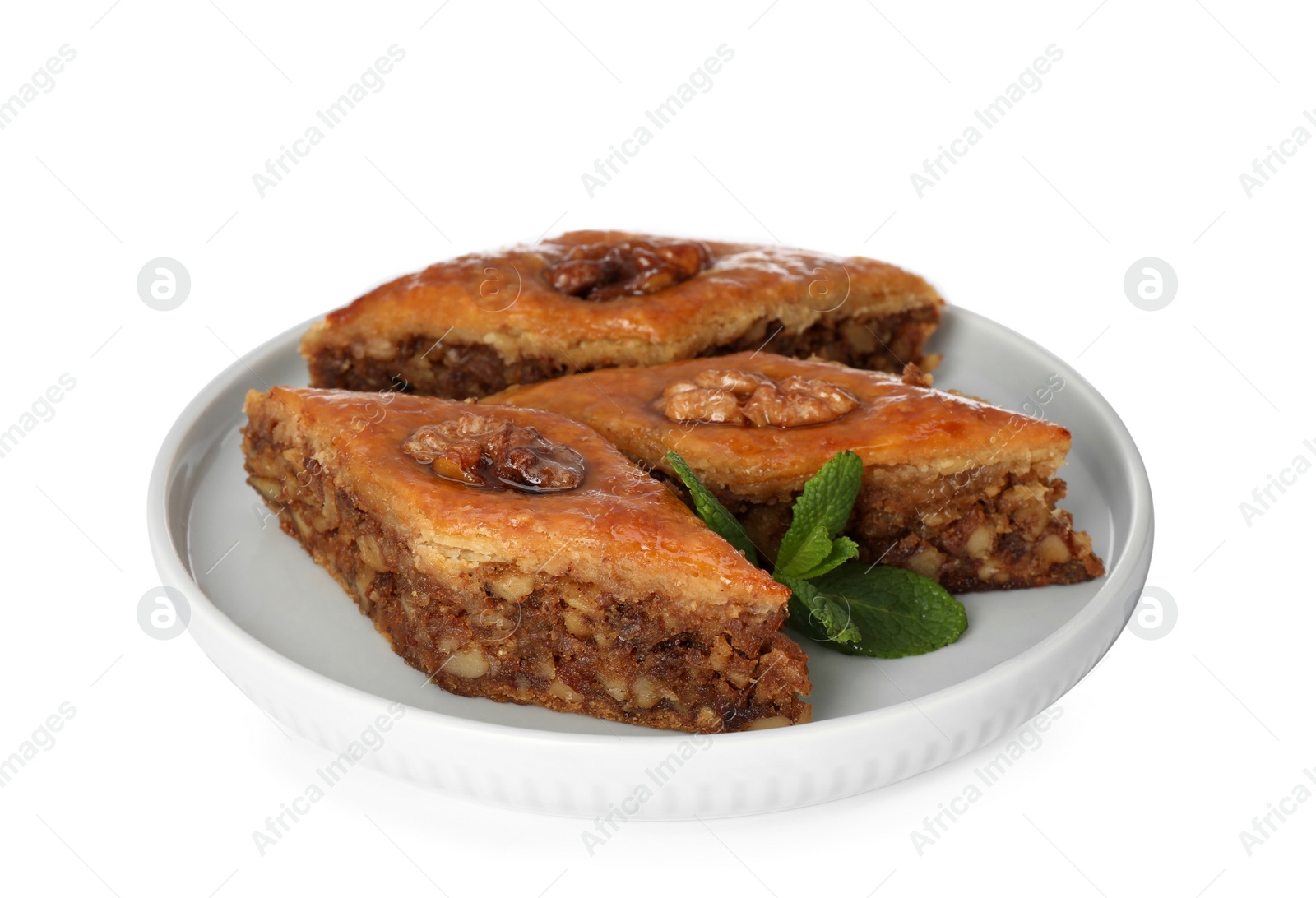 Photo of Plate of delicious honey baklava with walnuts on white background