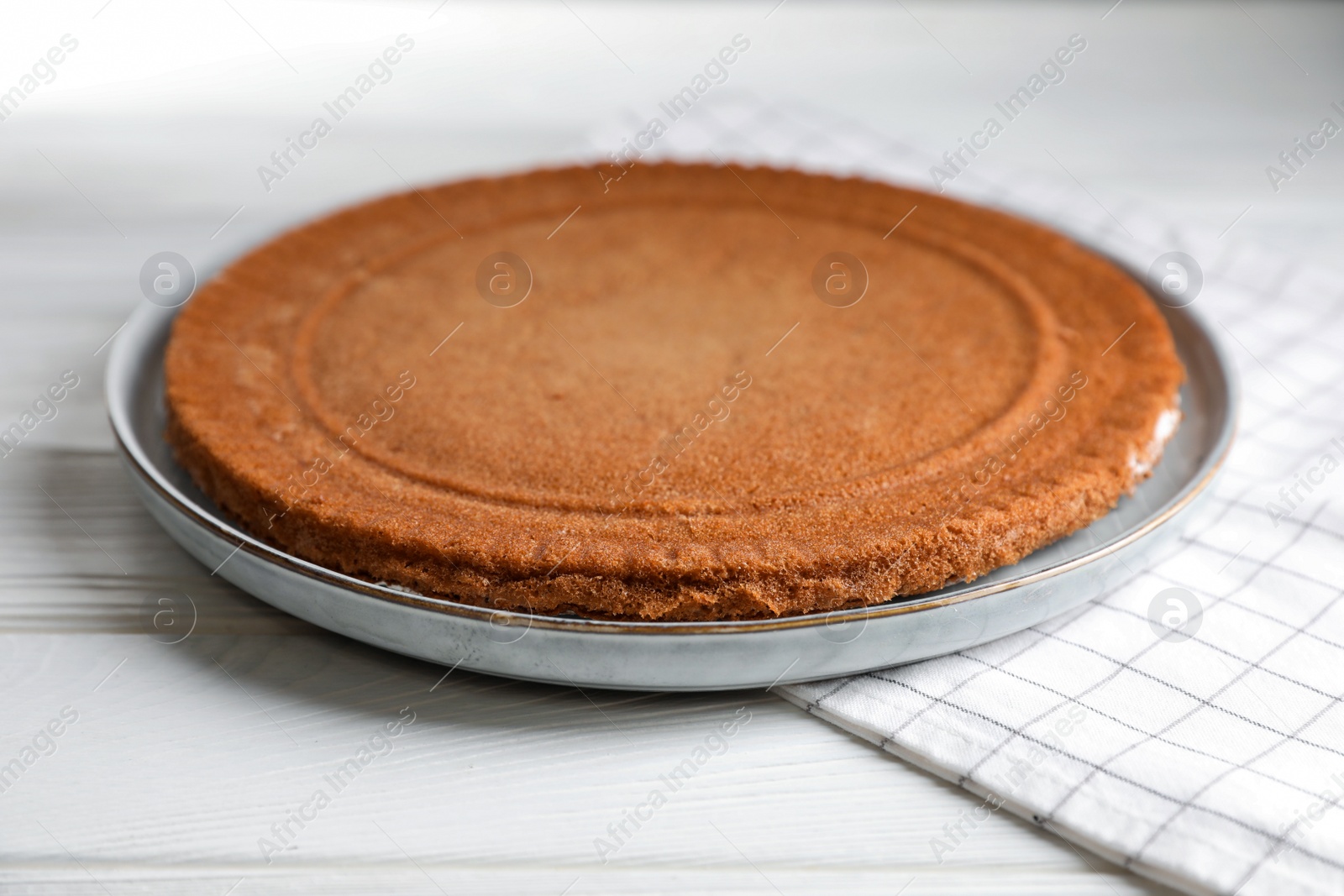 Photo of Delicious homemade sponge cake on white wooden table, closeup