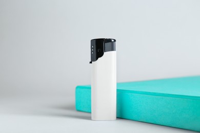 Photo of Stylish presentation of small pocket lighter on white background
