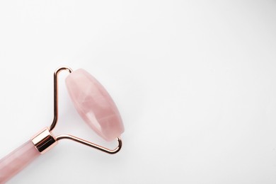 Rose quartz face roller on white background, top view