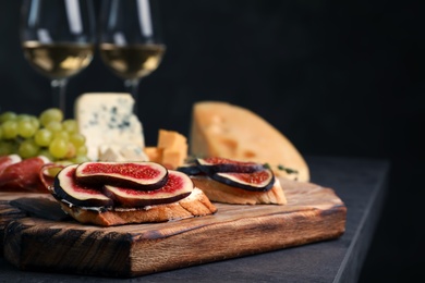 Photo of Sandwiches with ripe figs on wooden board, closeup