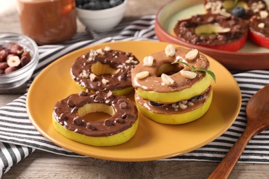 Photo of Fresh apples with nut butters, peanuts and chocolate chips on table