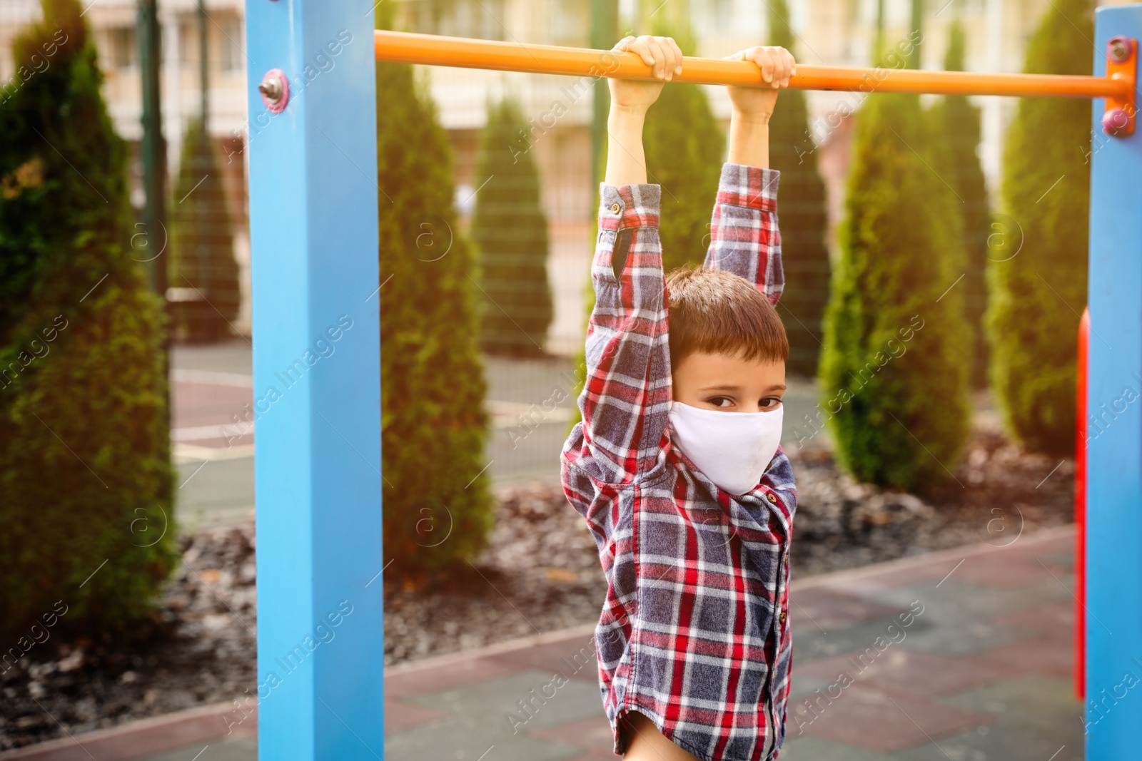 Photo of Little boy with medical face mask on playground during covid-19 quarantine