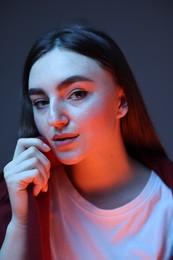Portrait of beautiful woman on dark blue background in neon lights